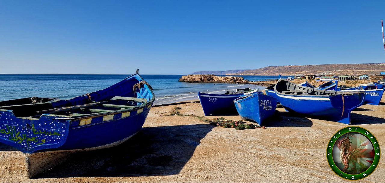 In the quiet fishing villages of Taghazout and Tameaght, life revolves around the sea. For generations, families have set sail in small wooden boats, relying on the Atlantic’s bounty to sustain their communities. But now, these villages face an existential crisis, one brought about not by natural forces but by international agreements and the dominance of industrial fishing fleets.

The EU-Morocco fisheries agreements, often presented as mutually beneficial, have had devastating consequences for Morocco’s small-scale fishing communities. These deals grant access to EU fleets, primarily Spanish and Portuguese, to fish in Moroccan waters, including the disputed waters off Western Sahara. While these fleets operate with state-of-the-art technology and at industrial scales, the family-run boats of Taghazout and Tameaght are left struggling to compete.